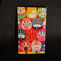 Porte-cartes Tsukimi fermé, en tissu japonais à darumas et shiba inu colorés sur fond rouge