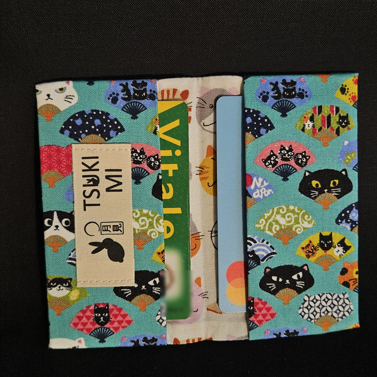 Porte-cartes Tsukimi éventails et chats turquoise, ouvert avec deux cartes glissées dans les compartiments