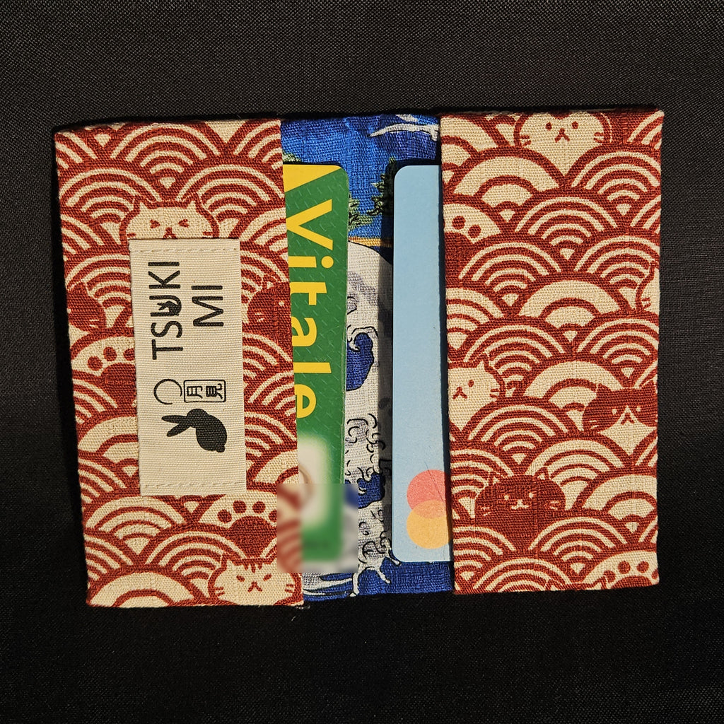 Porte-cartes Tsukimi seigaiha rouge et chats, ouvert avec deux cartes glissées dans les compartiments